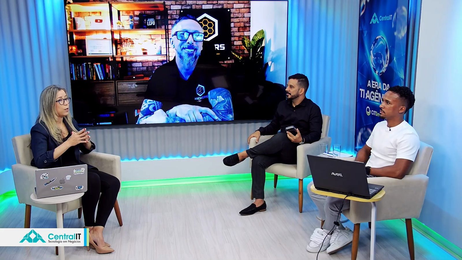 Paullyanna Gomes leads the audience questions in the studio, with Daniel Donda on the big screen and Gustavo Vilardi and Lucas Silva beside her
